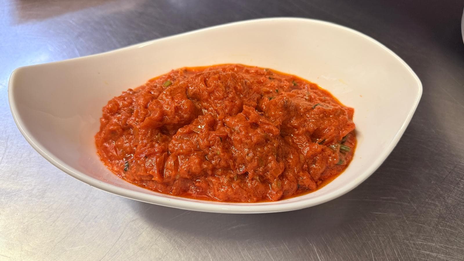 Chicken tikka in a wok, sizzling with peppers and onions