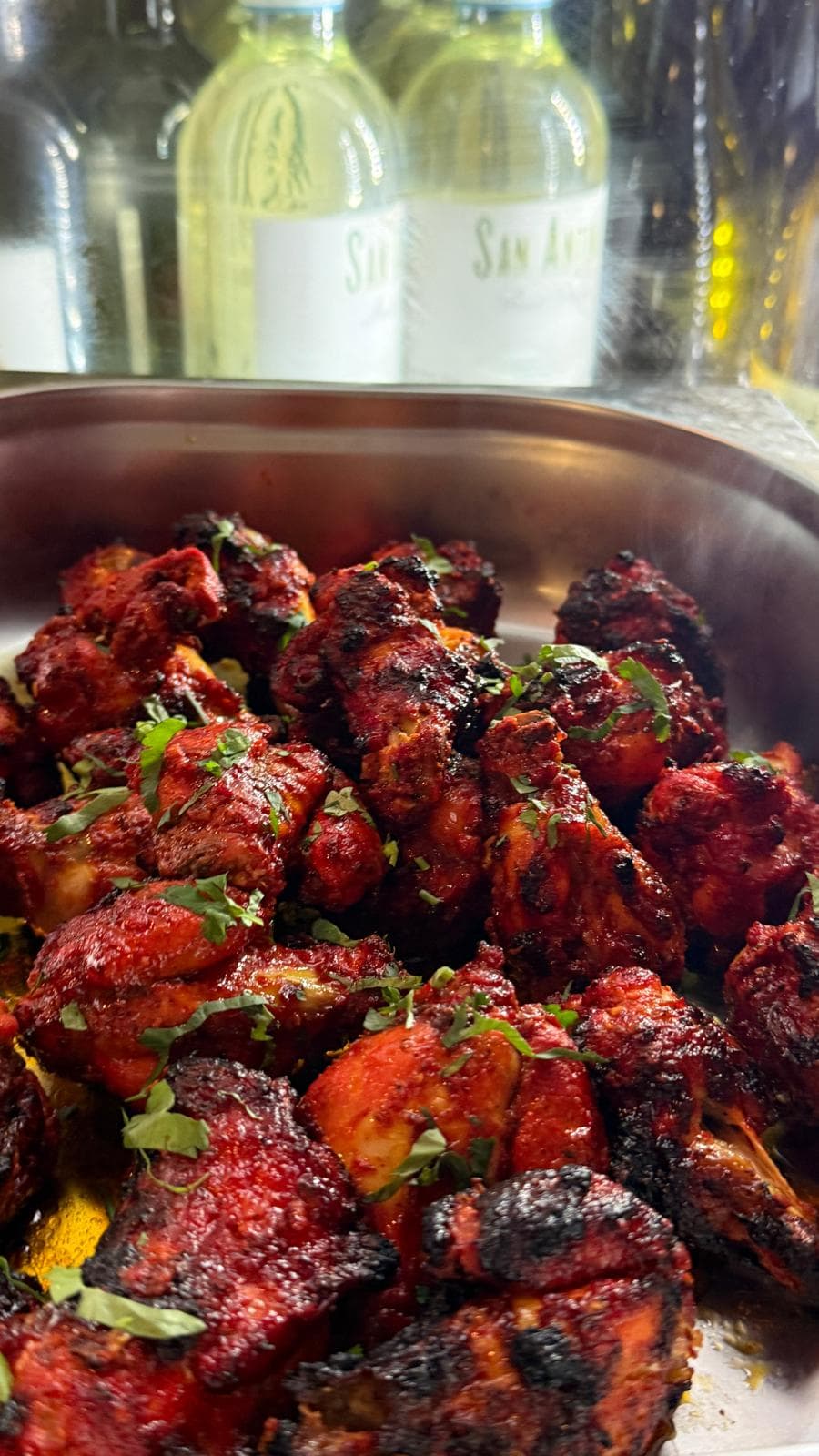 Chargrilled chicken tikka in a steel serving bowl